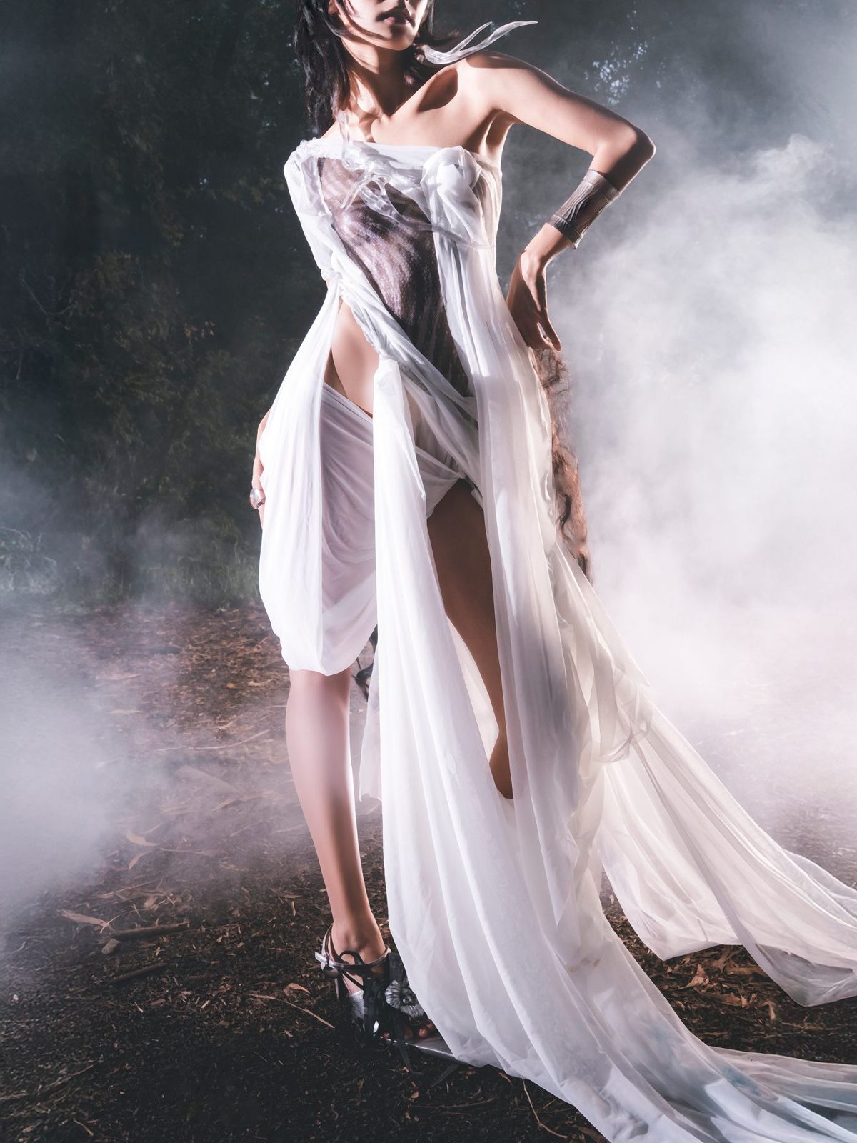 Model in a flowing white gown surrounded by haze